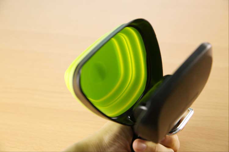 Green and white dog poop scooper folded for storage