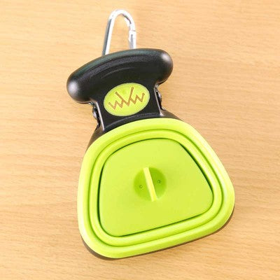 Green and white dog poop scooper opened for use